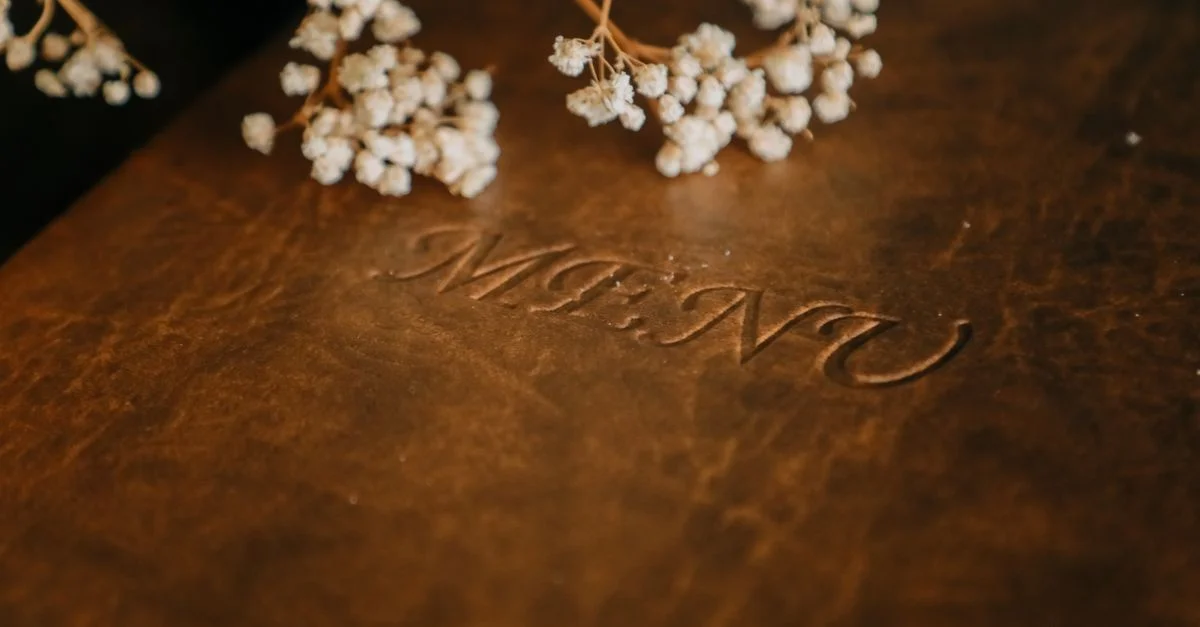 Primer plano de un menú de cuero marrón decorado con flores de bebé, perfecto para ambientes de restaurantes de alta gama.