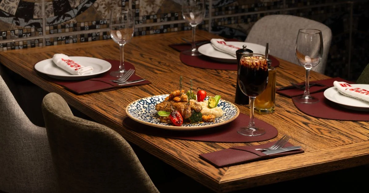 Ambiente acogedor en la mesa del restaurante, con elegantes aperitivos y vino, ideal para una experiencia gastronómica de alta calidad.