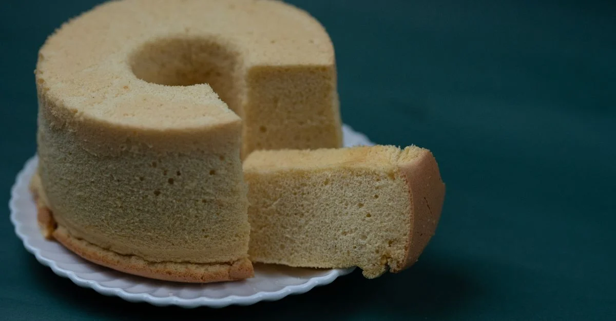 Disfruta de una porción de pastel de esponja ligero y esponjoso casero en un plato blanco.