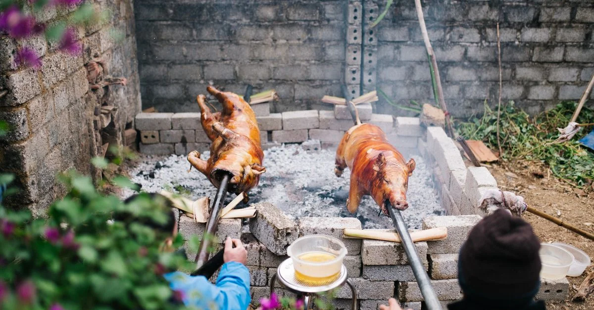 Scène authentique de rôtissage de porc à Lạng Sơn, Vietnam, mettant en avant des techniques culinaires culturelles.