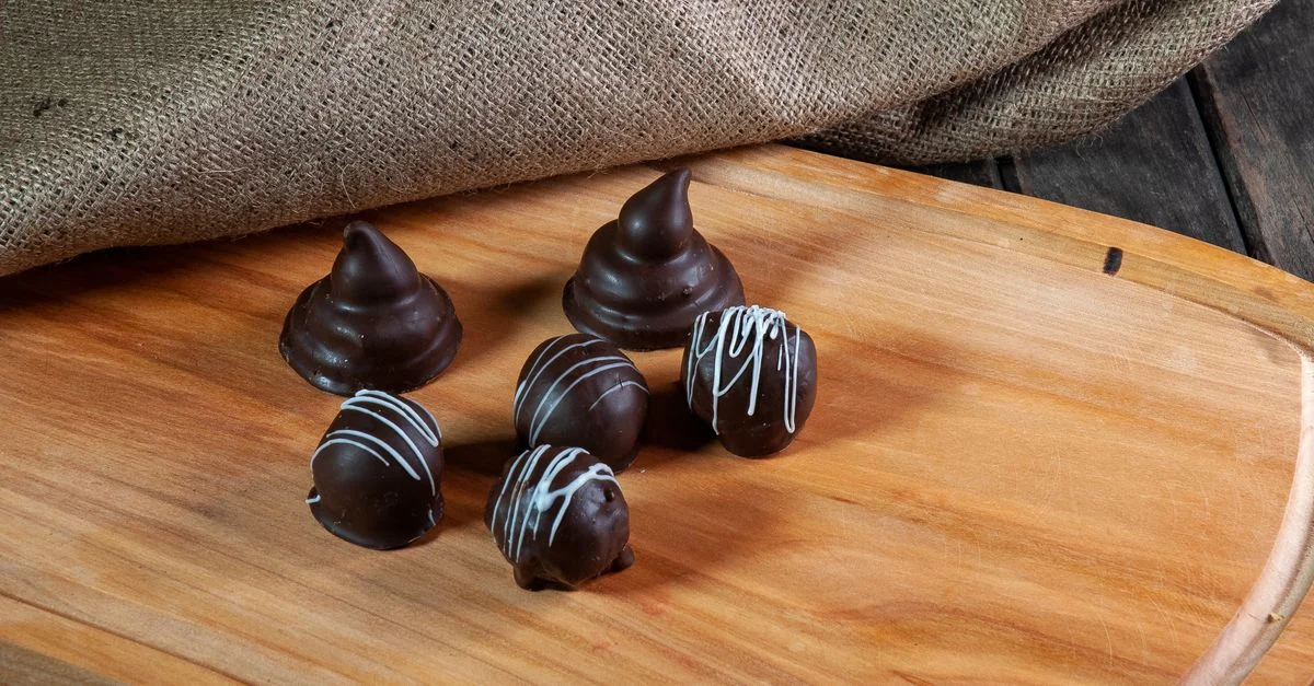 Trufas de chocolate gourmet dispuestas en una tabla de madera rústica, perfectas para inspirarse en la hora del postre.