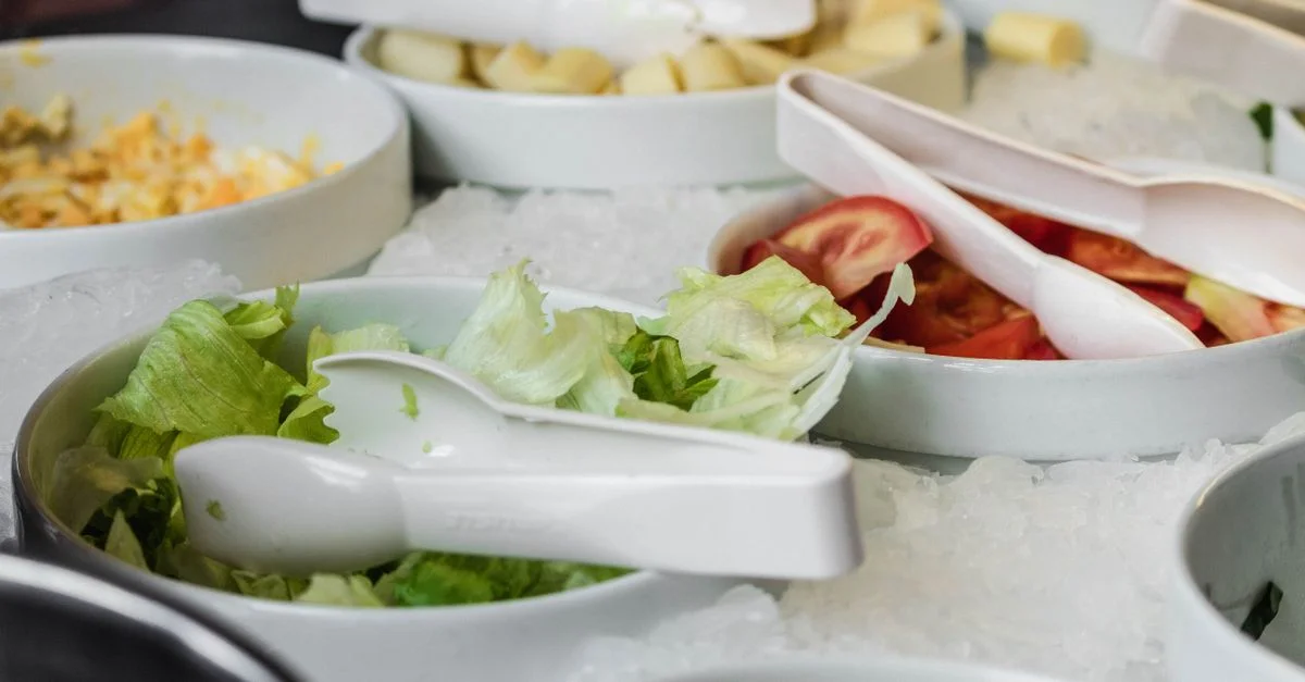 Vista en primer plano de cuencos de ensalada de verduras frescas con hielo en un restaurante buffet.