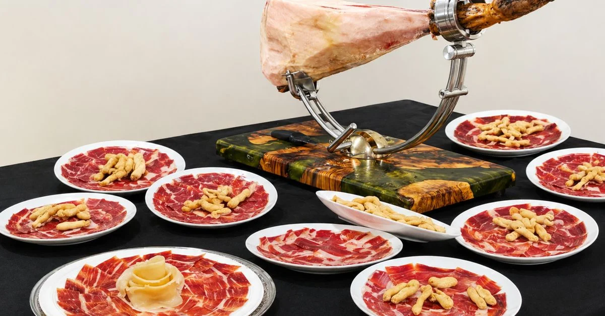 Elegante presentación de jamón serrano español en platos con palitos de pan, perfecta para una cena gourmet.