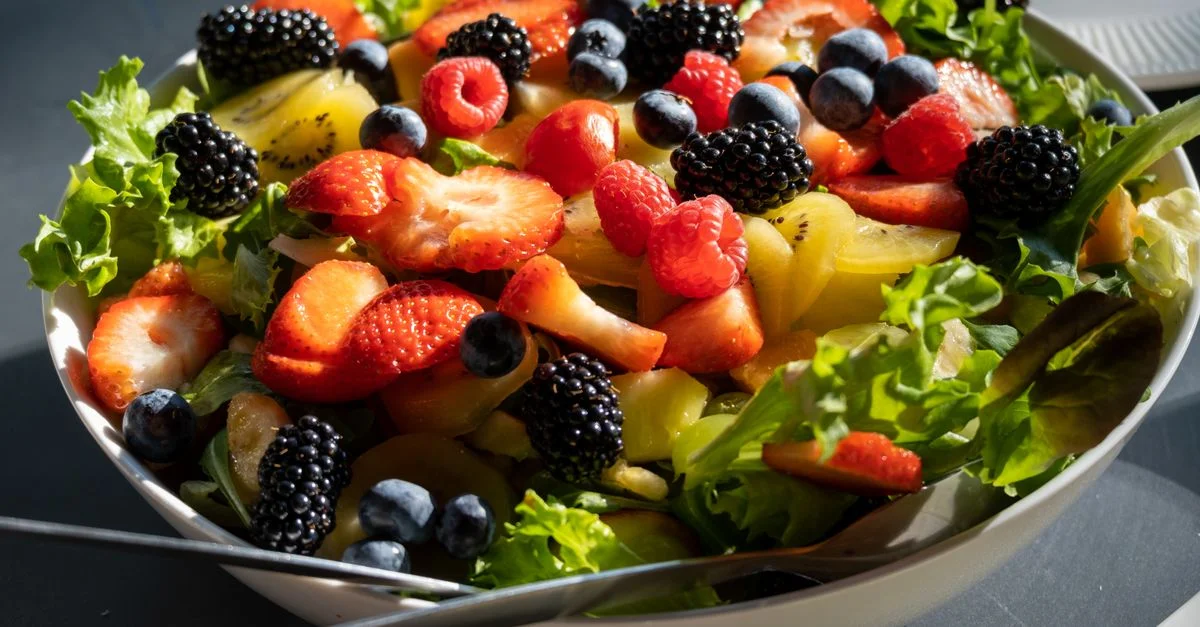 Ensalada colorida con fresas, arándanos y vegetales, perfecta para un estilo de vida saludable.